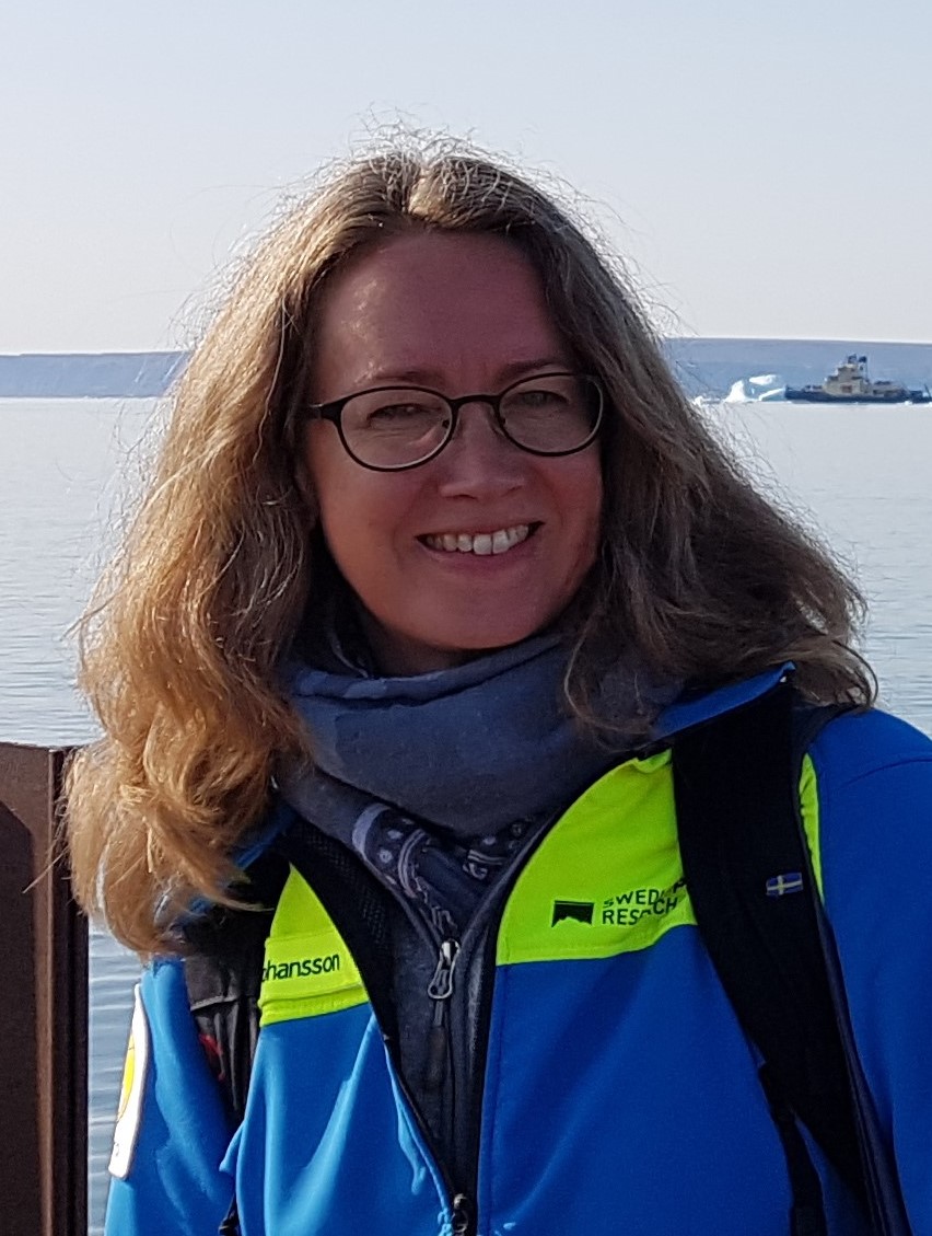 Portrait of Carina Johansson with the ocean and a boat in the background.