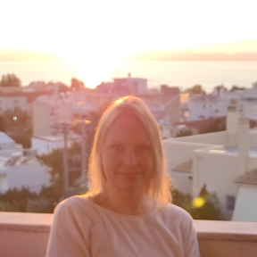 Portrait of Caronlina Nielsen with a city at sunset in the background.