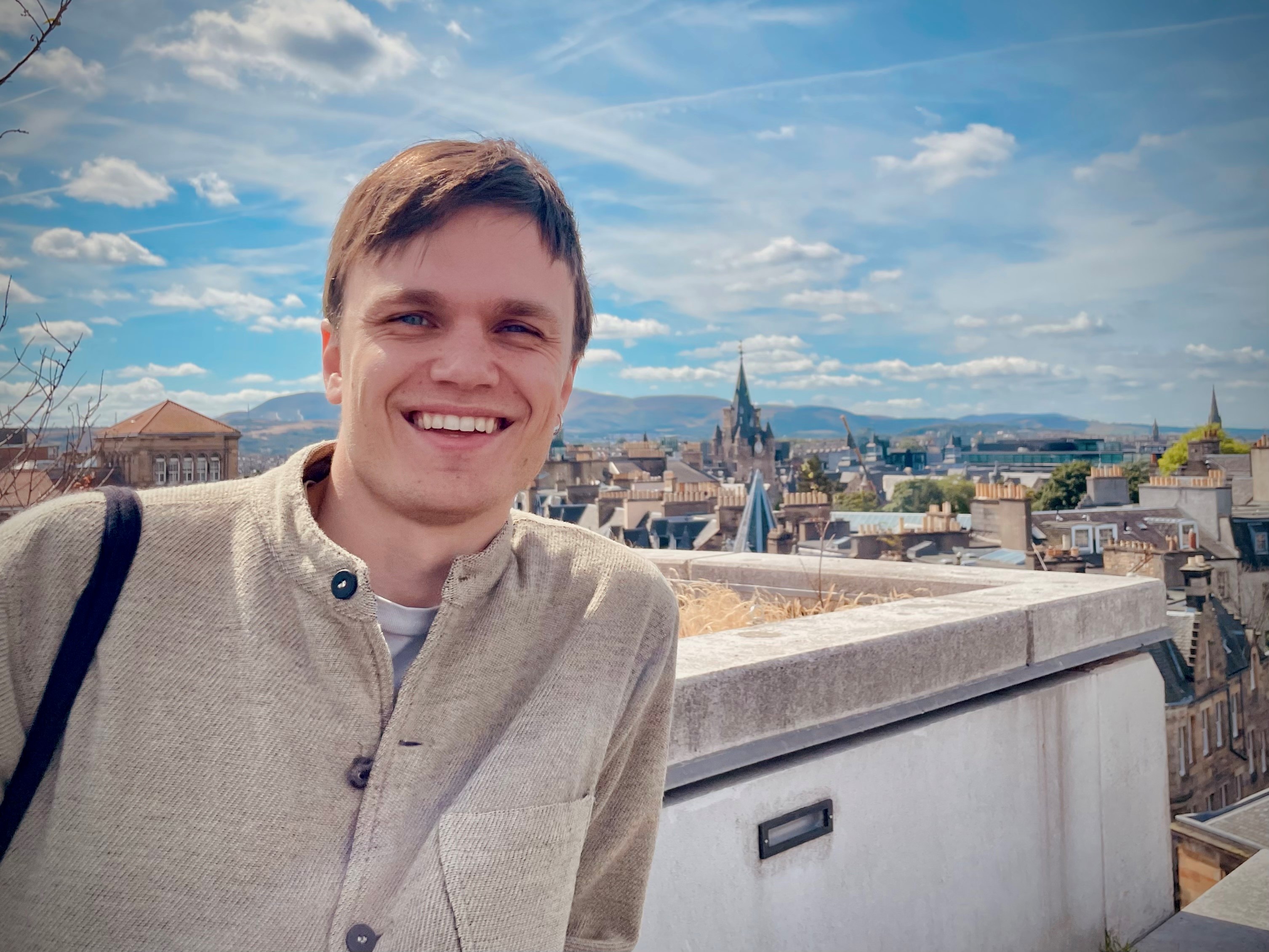 Portrait of Harad Carlinger with a city in the background.