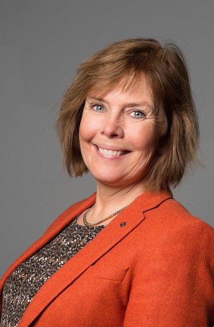 Portrait of Ingrid Hesser with a grey background.