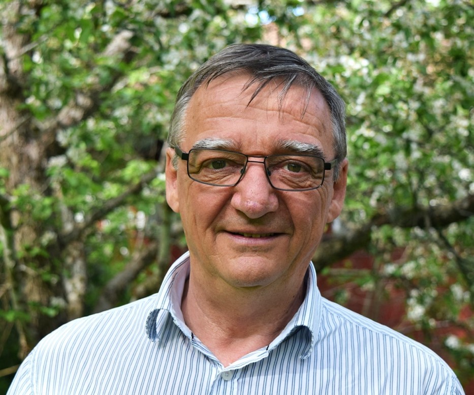 Portrait of Mike Jones with trees in the background.