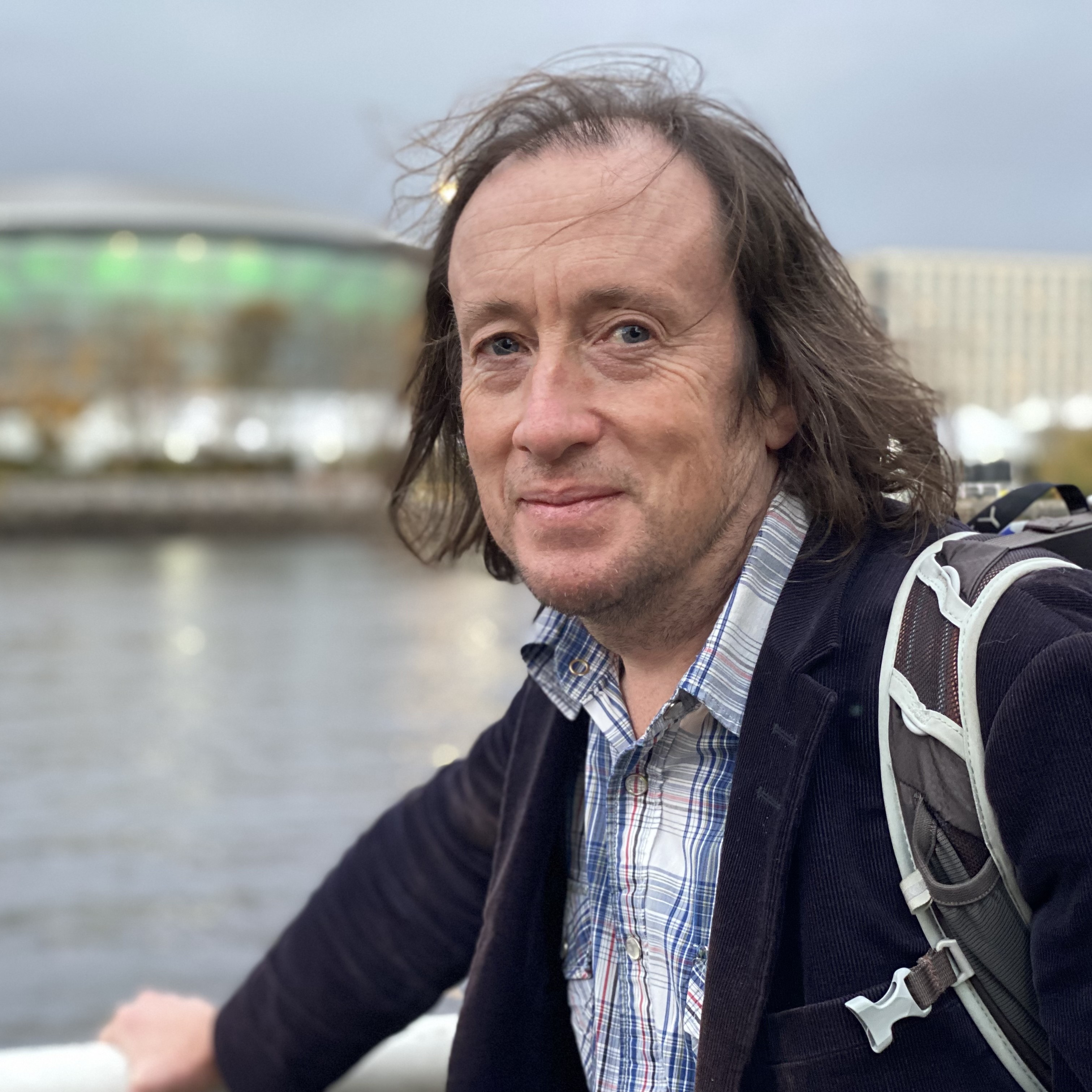 Portrait of Alasdair Skelton standing by a river.